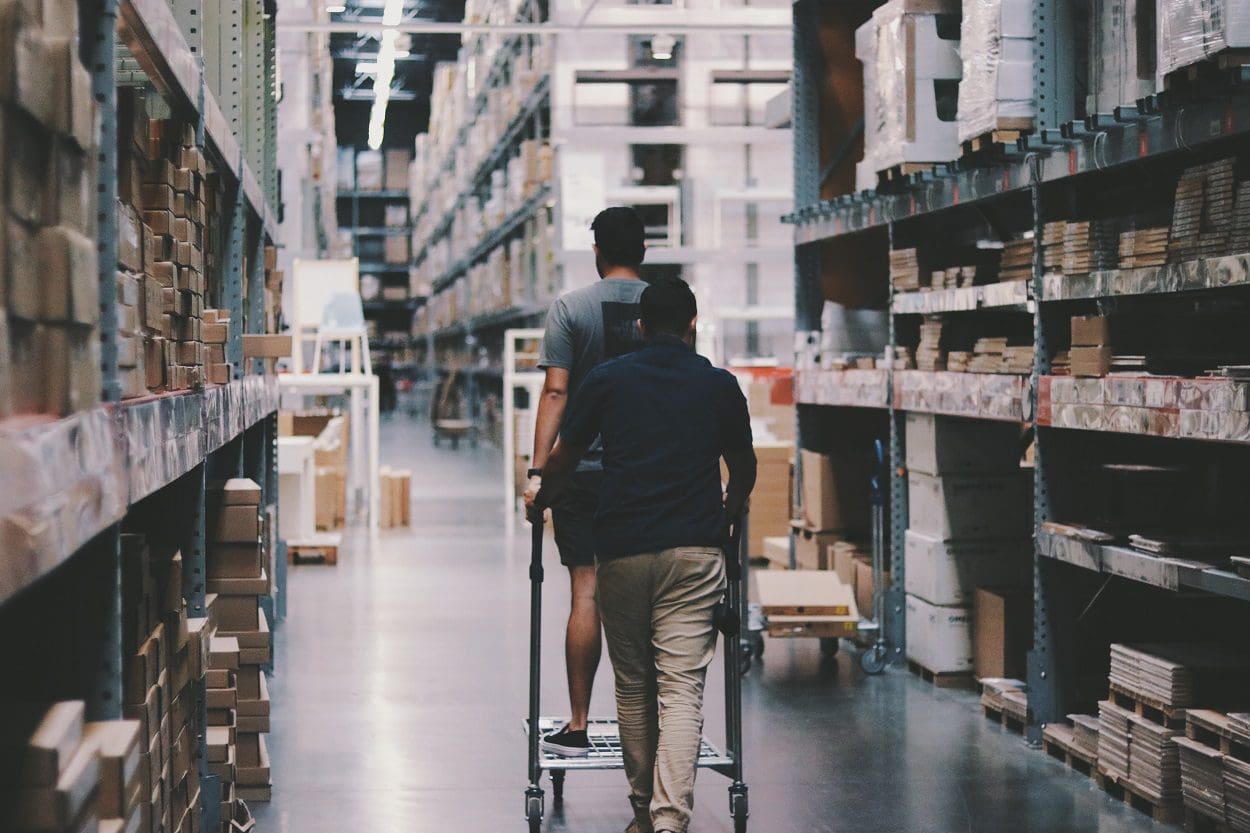 Two people walking in a large warehouse