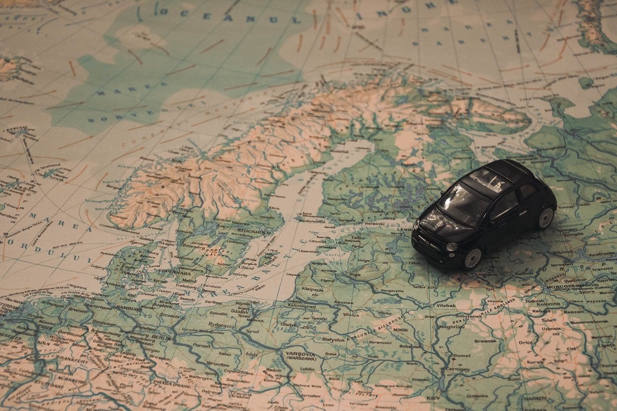 Black Toy Car on World Map Paper close to Sweden