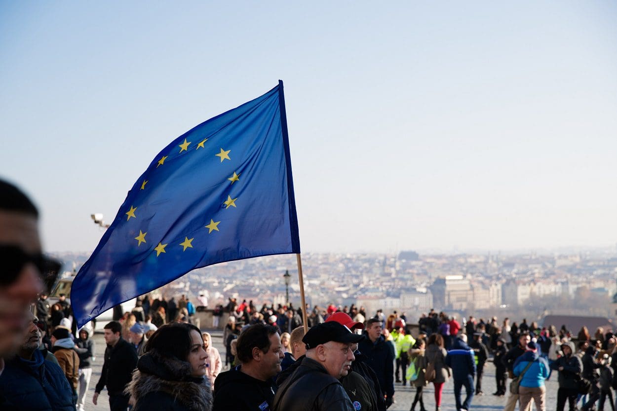 EU flag held by a man in the midst of several people