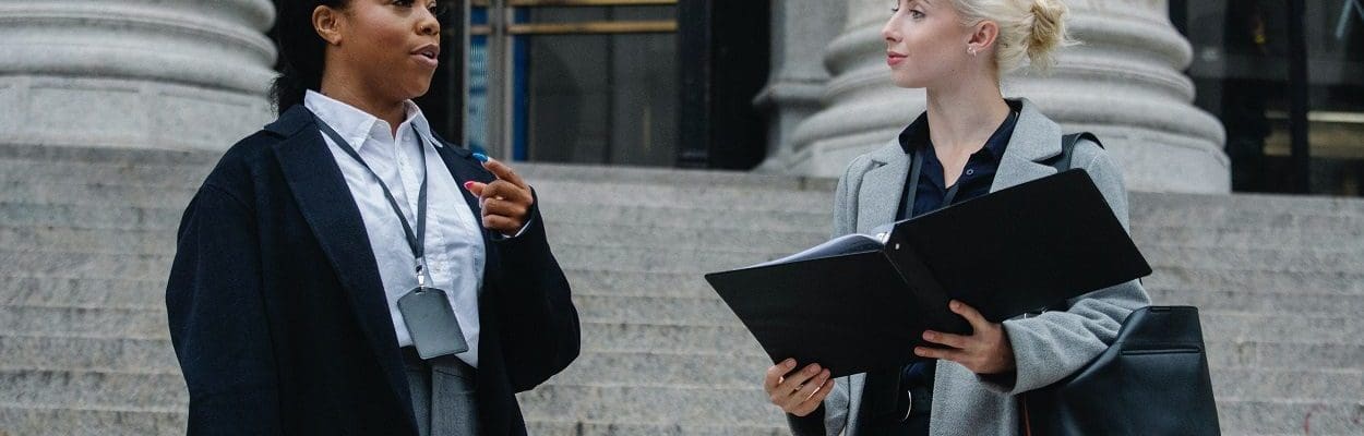 two lawyers speaking on steps of a courthouse
