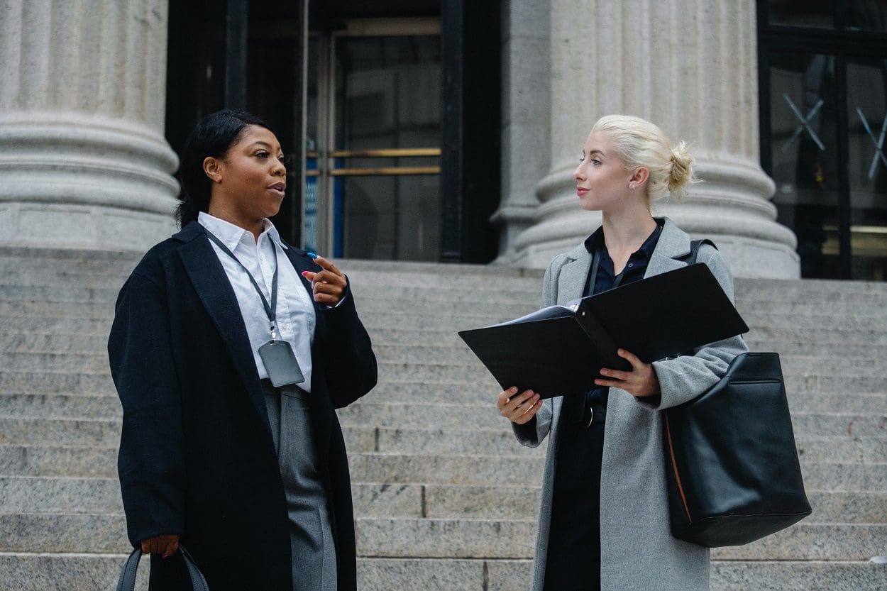 two lawyers speaking on steps of a courthouse
