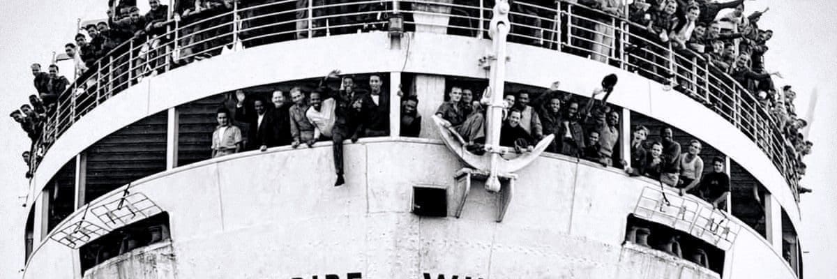 black and white photo of windrush ship with passengers visible