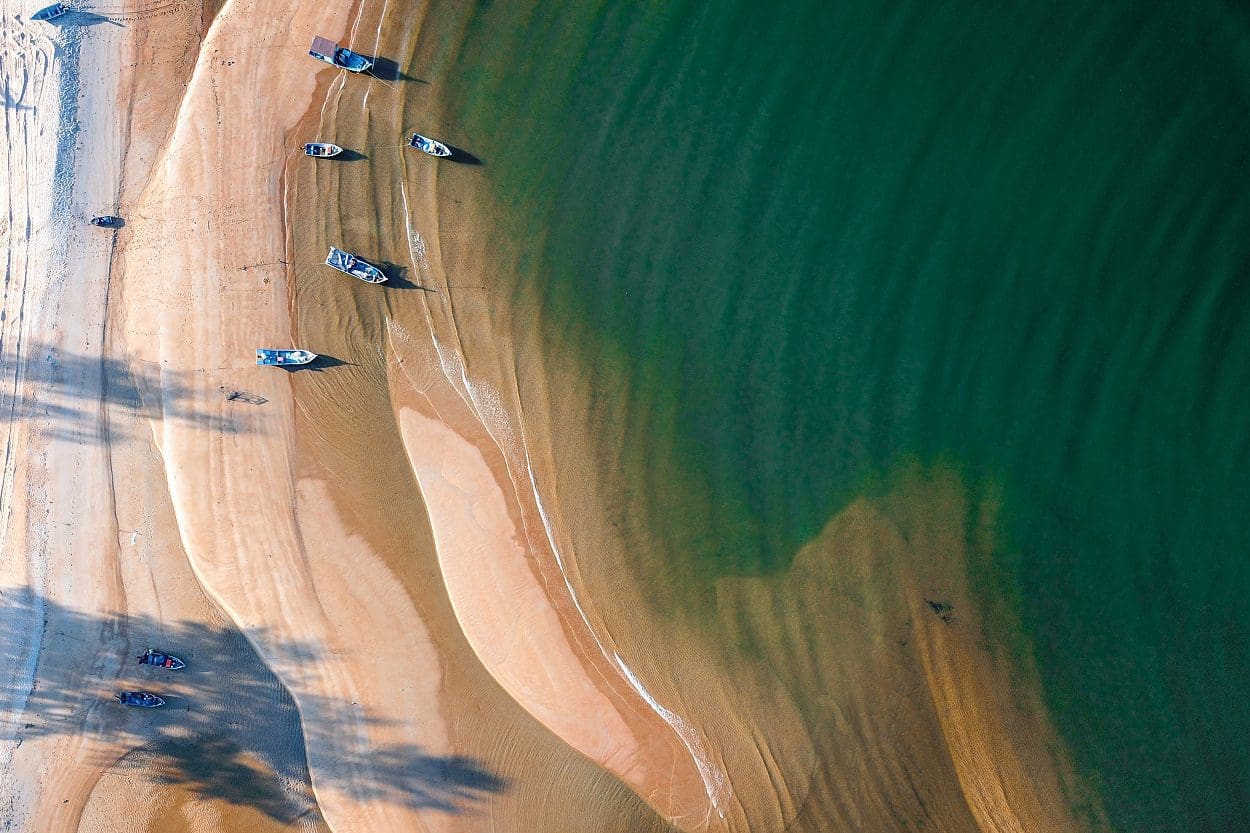 Sandy coast near azure ocean water