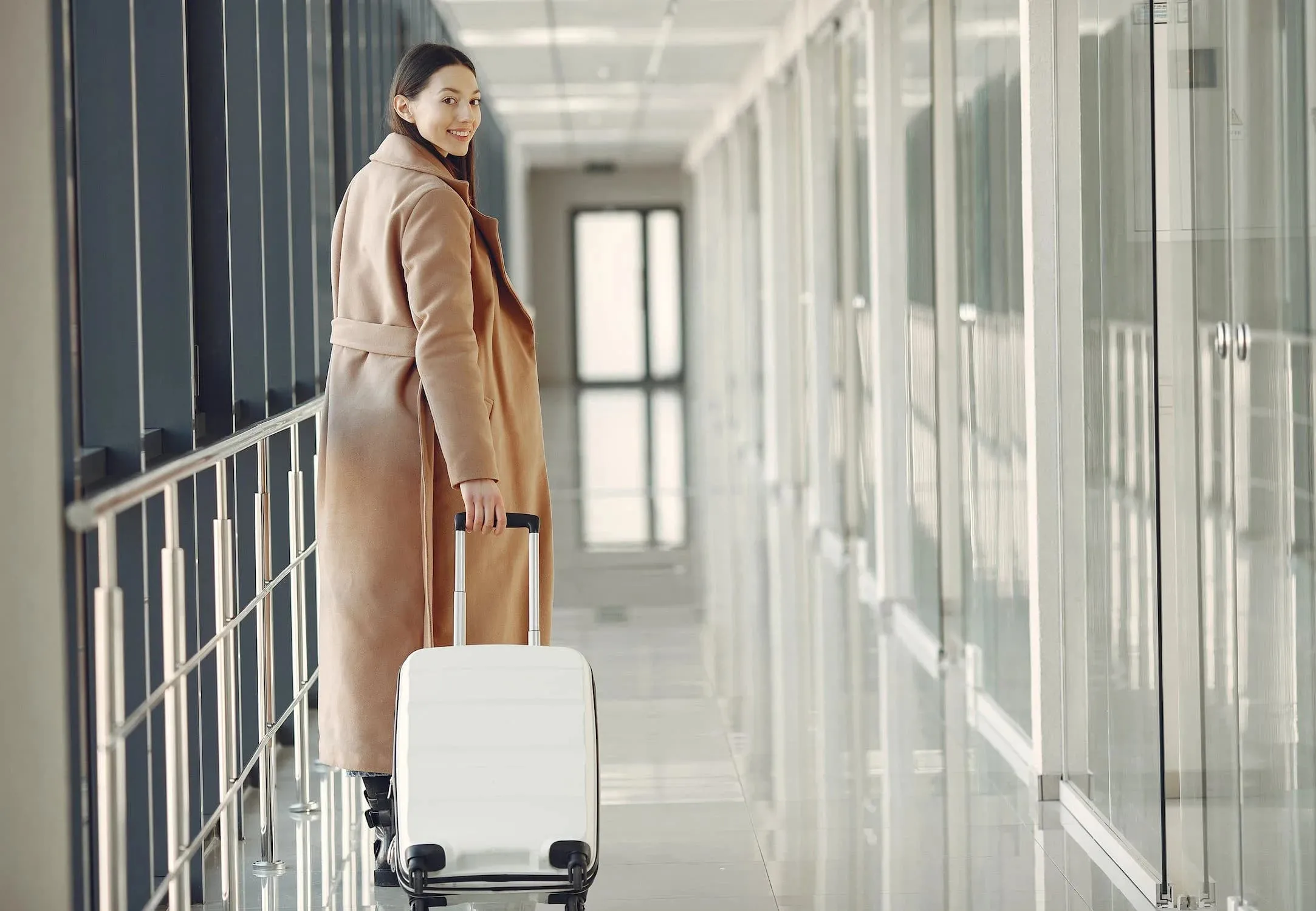a smiling woman with a white suitcase