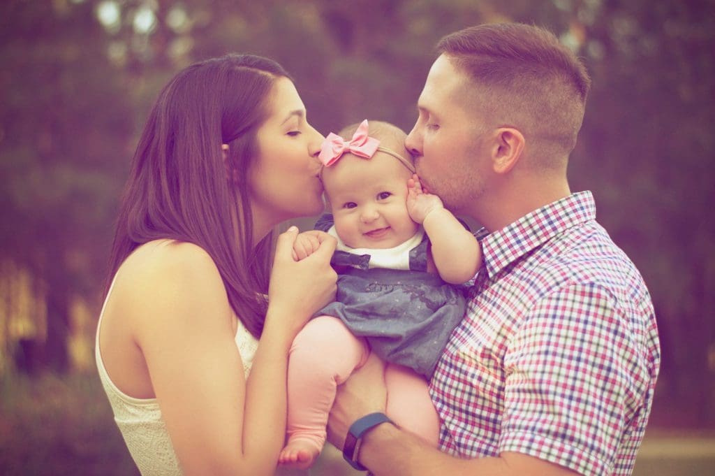 Parents kissing small child