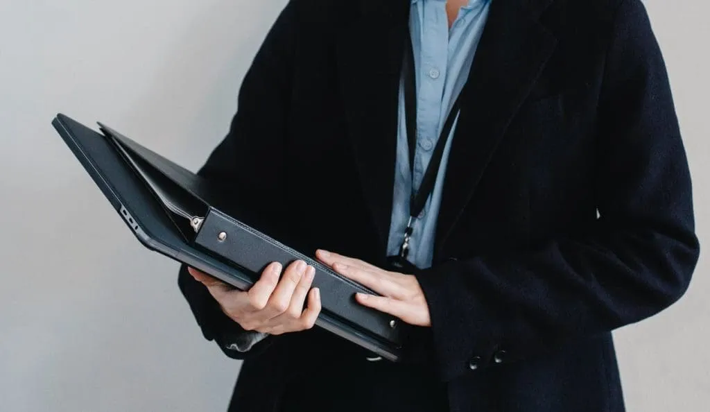 person in work uniform holding folder