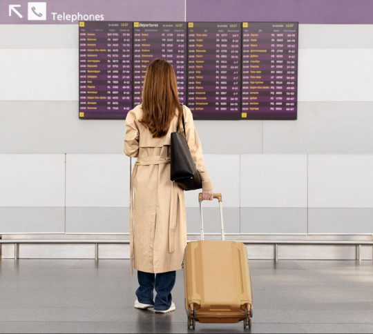 a woman in an airport with her baggage