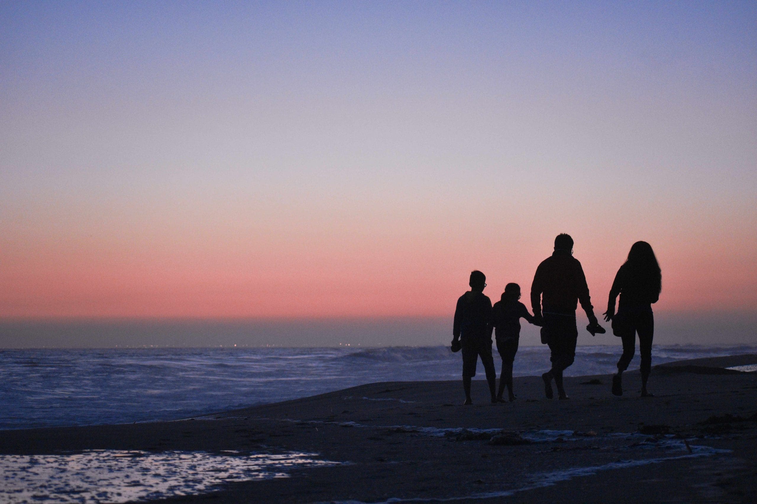silhouette of family standing on a beach