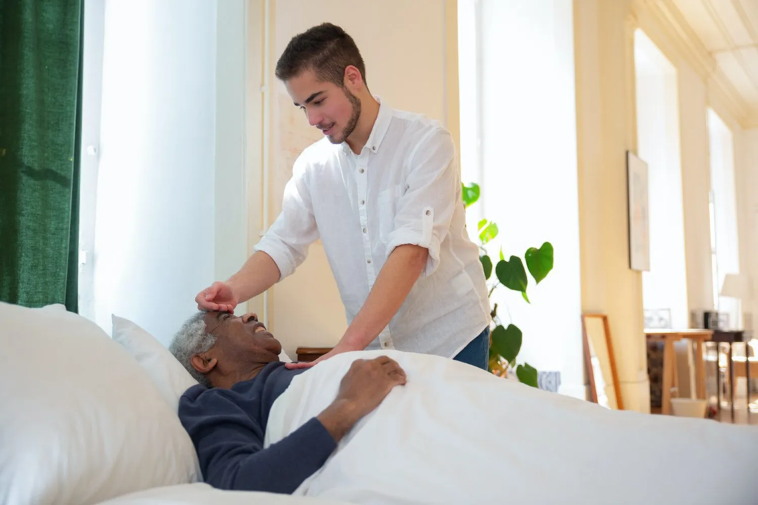 Caregiver checking man's temperature.