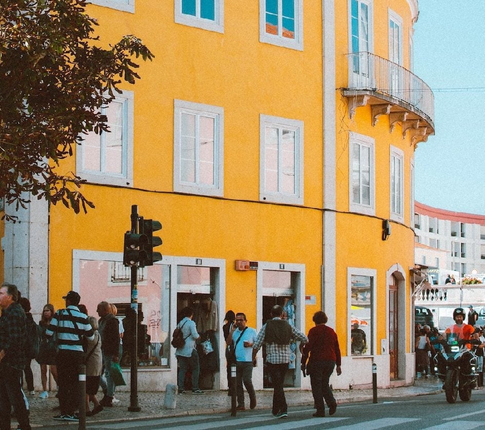 People walking beside yellow building in Portugal