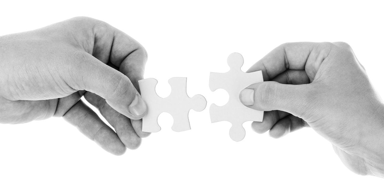 hands holding apart puzzle pieces