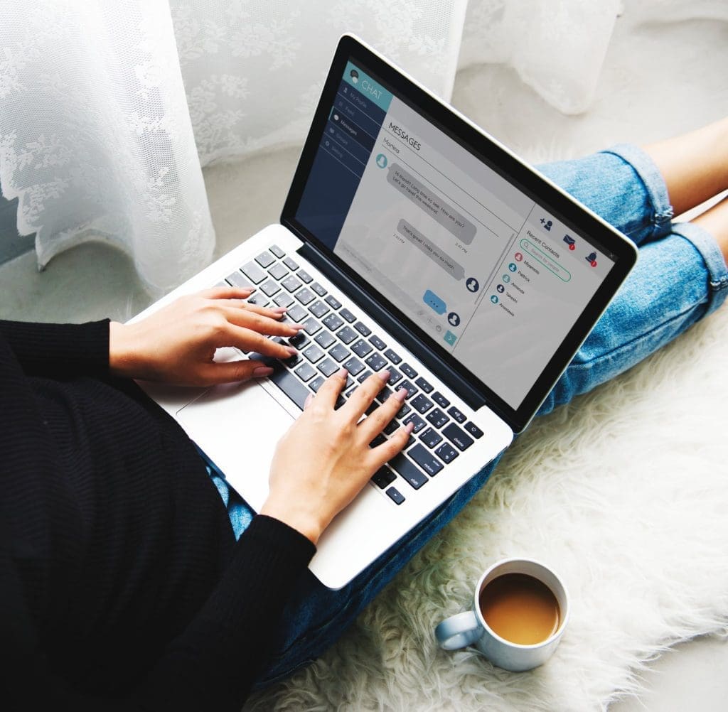 individual typing on her laptop