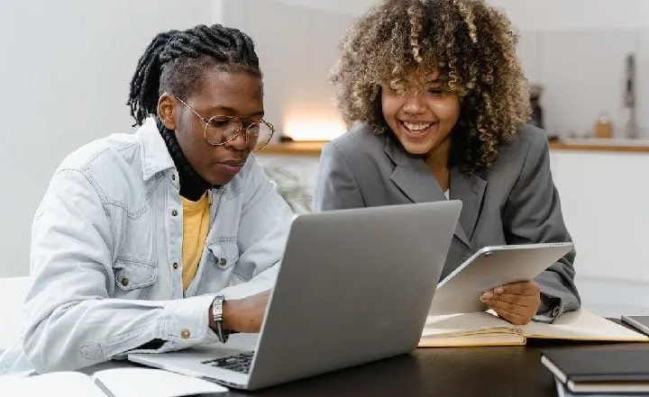 Man and woman filling out form on laptop