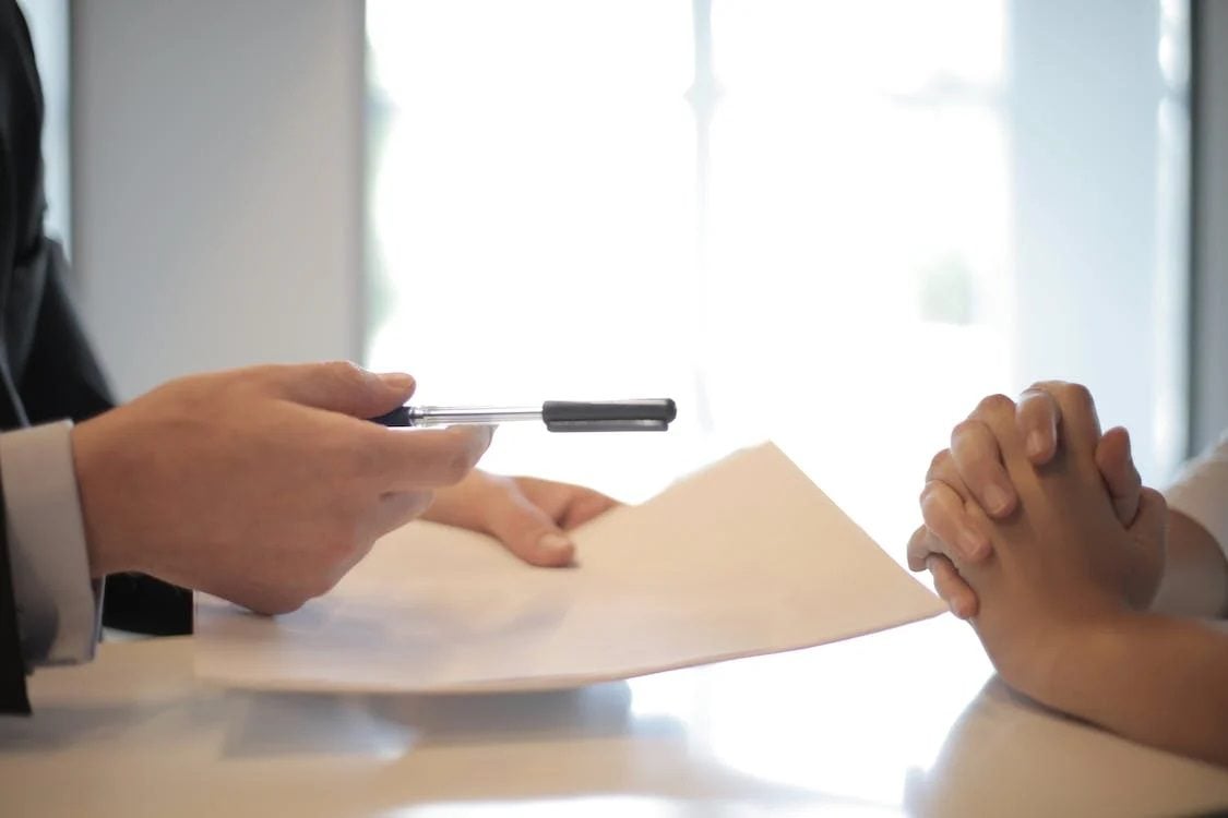 Handing over a pen to sign document
