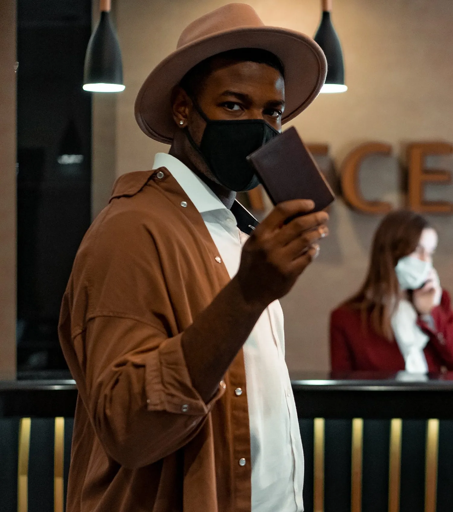 Adult wearing mask, holding up passport