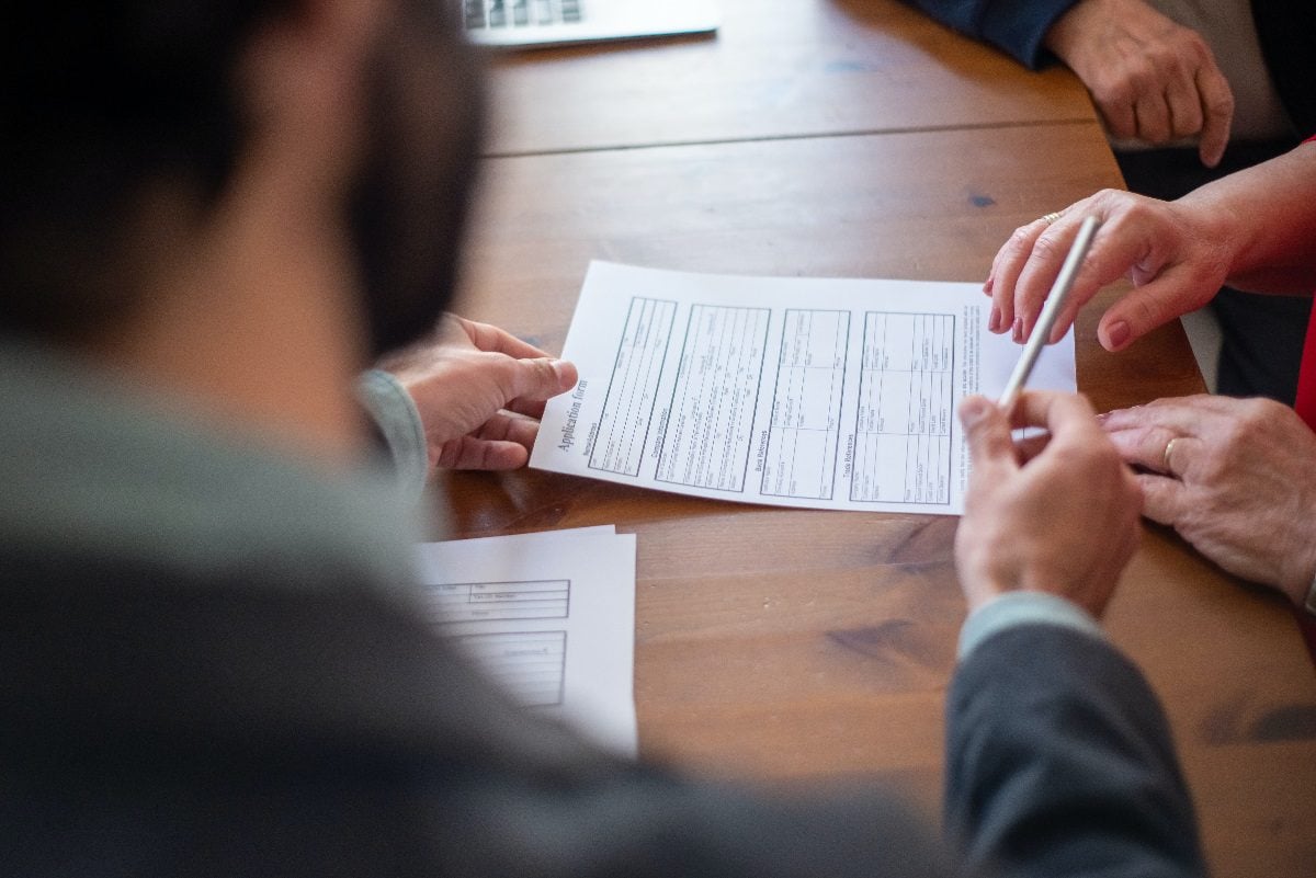 Lawyer giving client pen to sign document