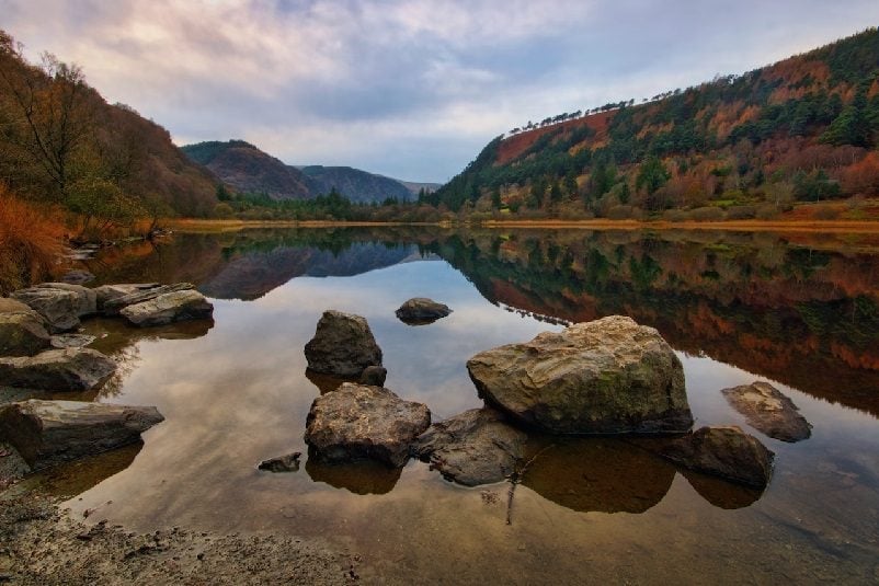 Body of water with visible rocks amidst cliffs