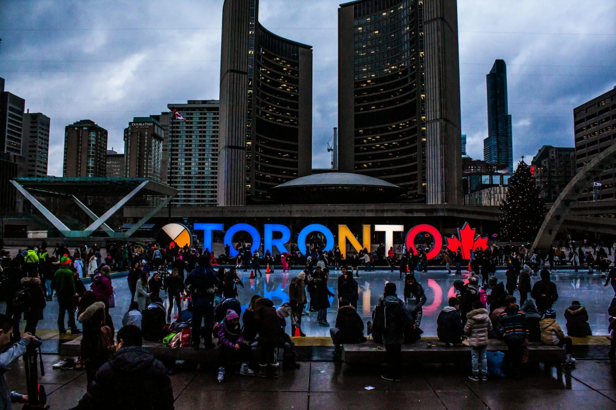 people gathering in front of Toronto signage in Canada