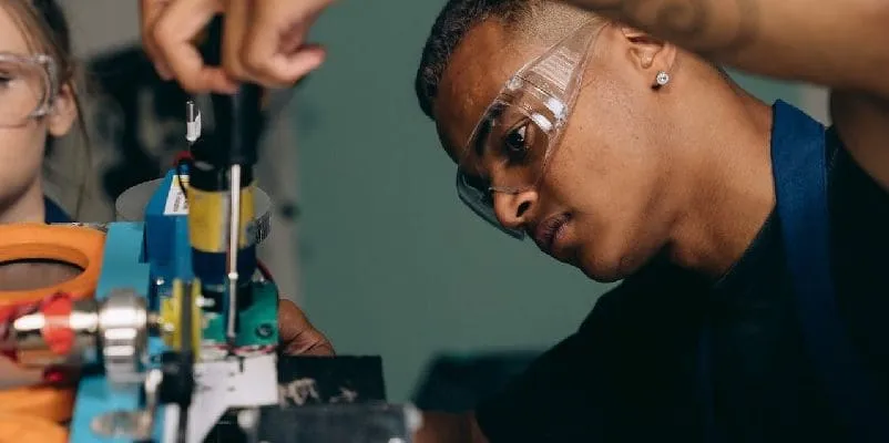 Man wearing safety glasses and using screwdriver