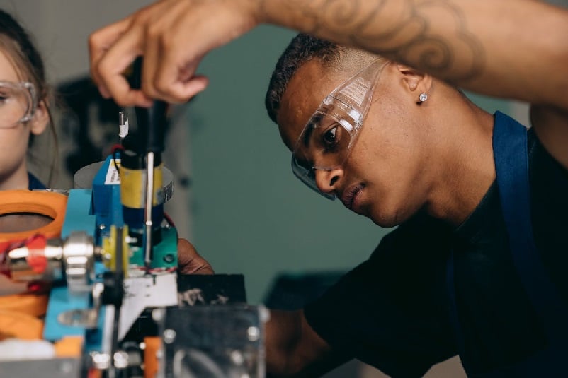 Man wearing safety glasses and using screwdriver