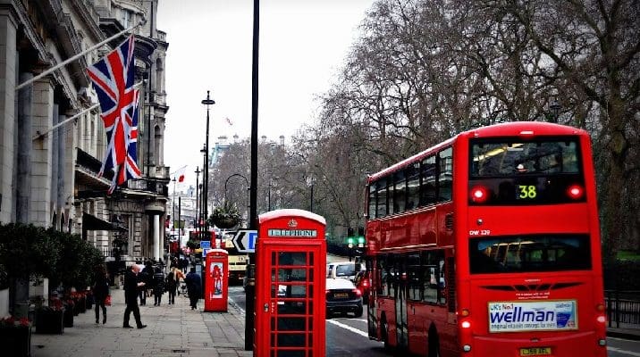 Red double-decker bus next to phone booth