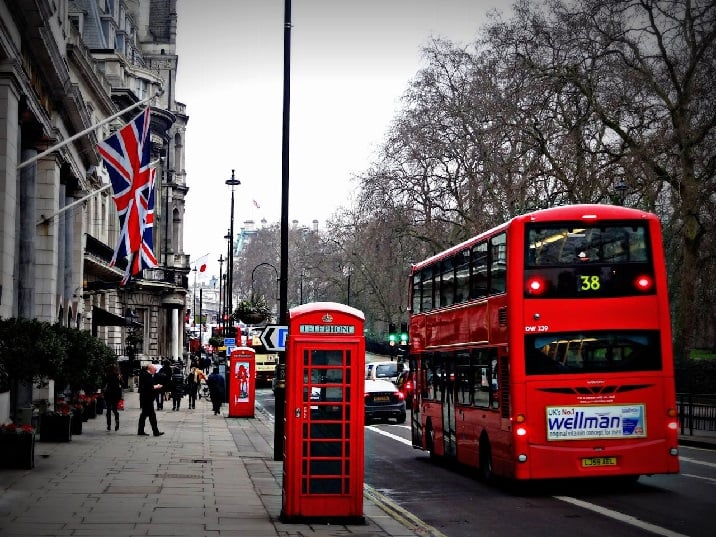 Red double-decker bus next to phone booth