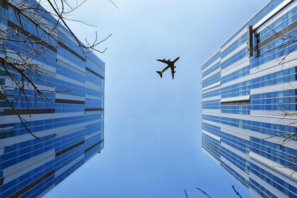 an airplane fly over high rise buildings