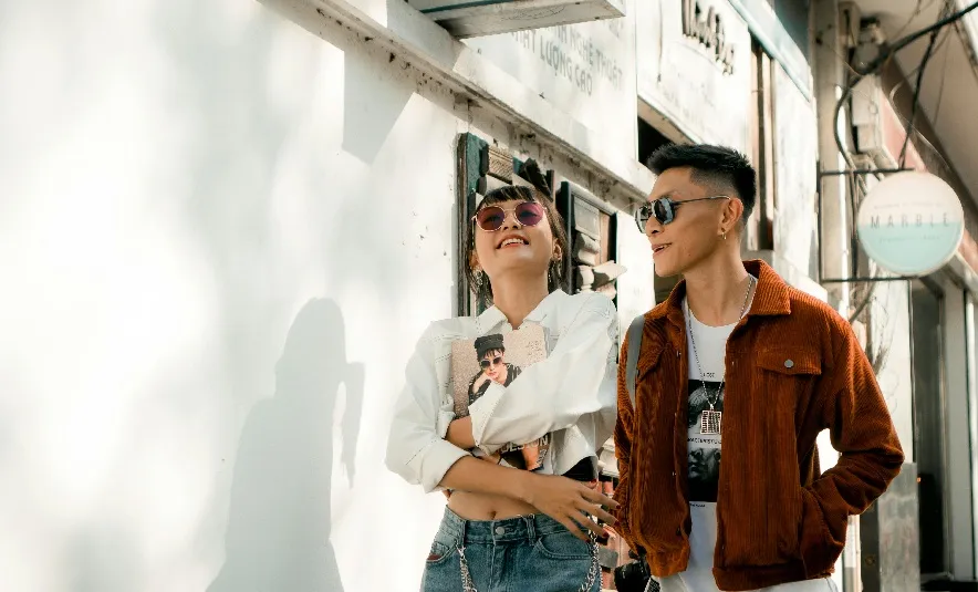 Young couple, walking beside a building
